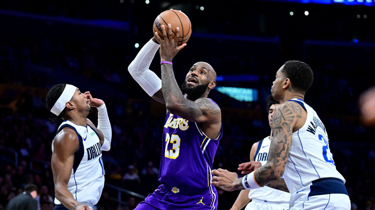 LOS ANGELES, CALIFORNIA - FEBRUARY 12: LeBron James #23 of the Los Angeles Lakers drives to the basket between Brandon Williams #10 (L) and P.J. Washington #25 of the Dallas Mavericks in the second half at Crypto.com Arena on February 12, 2026 in Los Angeles, California.