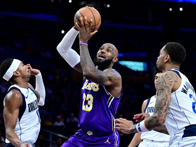 LOS ANGELES, CALIFORNIA - FEBRUARY 12: LeBron James #23 of the Los Angeles Lakers drives to the basket between Brandon Williams #10 (L) and P.J. Washington #25 of the Dallas Mavericks in the second half at Crypto.com Arena on February 12, 2026 in Los Angeles, California.