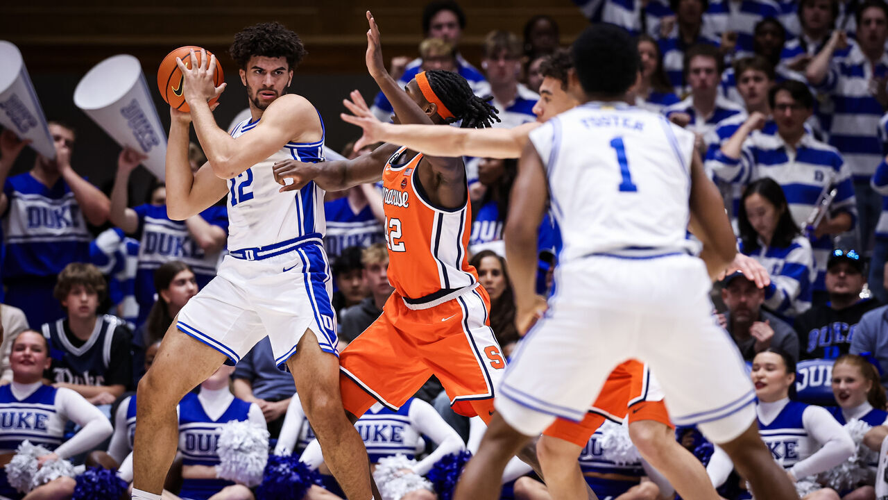 DURHAM, NORTH CAROLINA - FEBRUARY 16: Cameron Boozer #12 of the Duke Blue Devils looks to get past William Kyle III #42 of the Syracuse Orange during the first half of the basketball game at Cameron Indoor Stadium on February 16, 2026 in Durham, North Carolina.