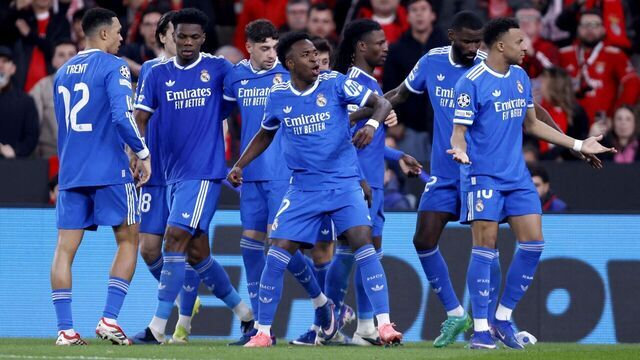 Real Madrid's Brazilian forward #07 Vinicius Junior (C) celebrates scoring his team's first goal with teammates during the UEFA Champions League knockout round play-off first leg football match between SL Benfica and Real Madrid CF at Estadio da Luz in Lisbon on February 17, 2026.