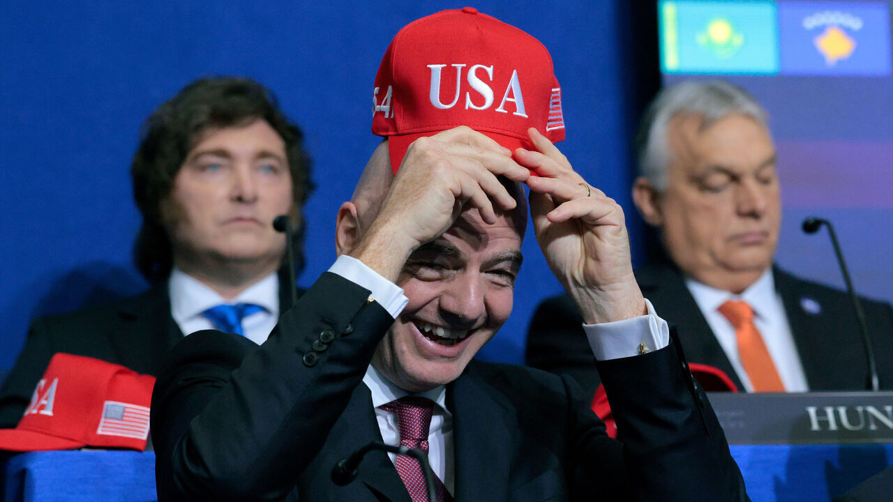 WASHINGTON, DC - FEBRUARY 19: President of FIFA Gianni Infantino holds up a USA hat as he attends the inaugural meeting of the Board of Peace at the Institute of Peace on February 19, 2026 in Washington, DC. Assembled to raise money for the rebuilding and stabilization of Gaza, Trump's Board of Peace was formally established on the sidelines of World Economic Forum in January of 2026.