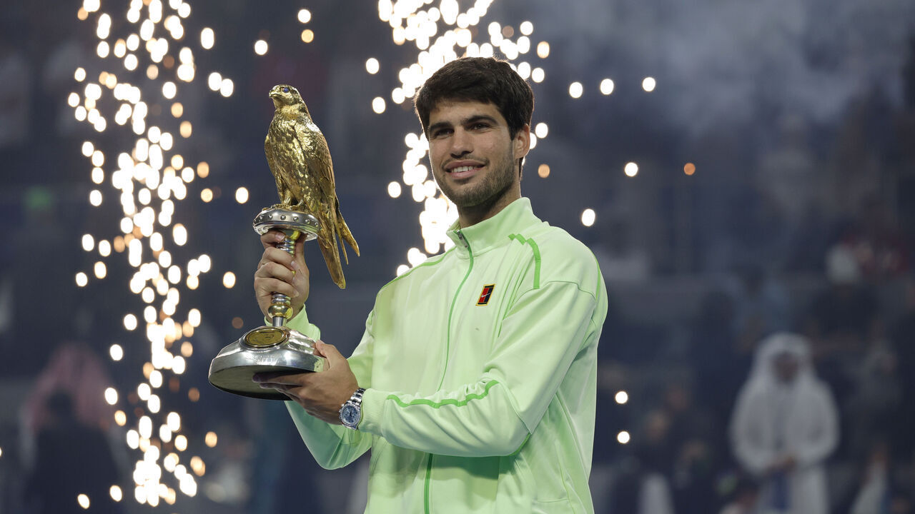 DOHA, QATAR - FEBRUARY 21: Carlos Alcaraz of Spain celebrates with the trophy after winning his men's singles final match against Arthur Fils of France at the Qatar ExxonMobil Open at Khalifa International Tennis and Squash Complex on February 21, 2026 in Doha, Qatar.