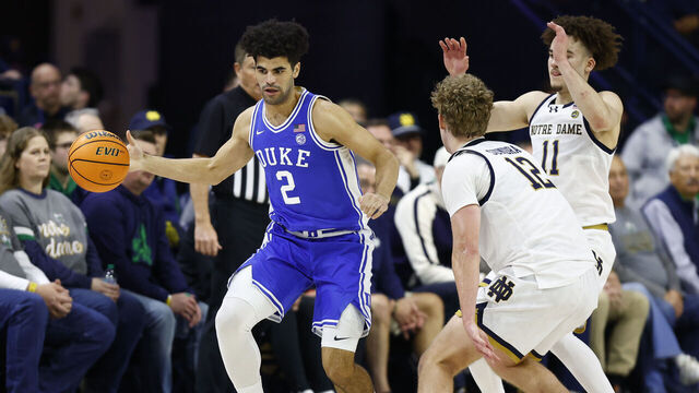 SOUTH BEND, IN - FEBRUARY 24: Duke Blue Devils guard Cayden Boozer (2) moves with the ball while defended by Notre Dame Fighting Irish forward Garrett Sundra (12) and Notre Dame Fighting Irish guard Braeden Shrewsberry (11) in the first half of play during a men's college basketball game between the Duke Blue Devils and the Notre Dame Fighting Irish on February 24, 2026 at Purcell Pavilion in South Bend, IN.