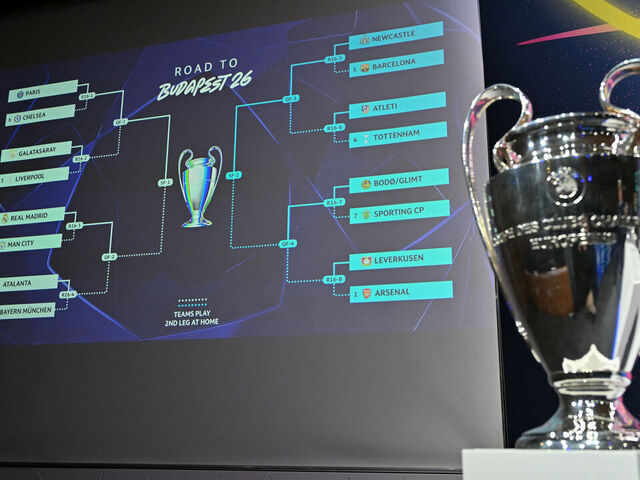 This photograph shows the UEFA Champions League Cup displayed next to a screen bearing the results of the 2025-2026 UEFA Champions League round of 16, quarter-final and semi-final draw at the House of European Football in Nyon, western Switzerland on February 27, 2026.