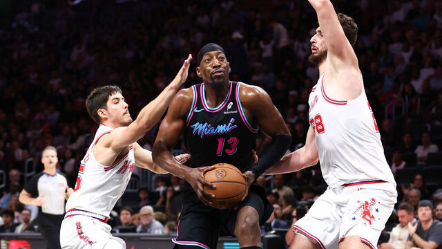MIAMI, FLORIDA - FEBRUARY 28: Bam Adebayo #13 of the Miami Heat drives against Reed Sheppard #15 and Alperen Sengun #28 of the Houston Rockets during the second quarter of the game at Kaseya Center on February 28, 2026 in Miami, Florida.