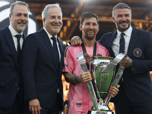 FORT LAUDERDALE, FLORIDA - DECEMBER 06: José Mas, Jorge Mas and Sir David Beckham, co-owners of Inter Miami CF pose with the Champion's trophy next to Lionel Messi #10 after winning the Audi 2025 MLS Cup Final match between Inter Miami CF and Vancouver Whitecaps FC at Chase Stadium on December 06, 2025 in Fort Lauderdale, Florida.