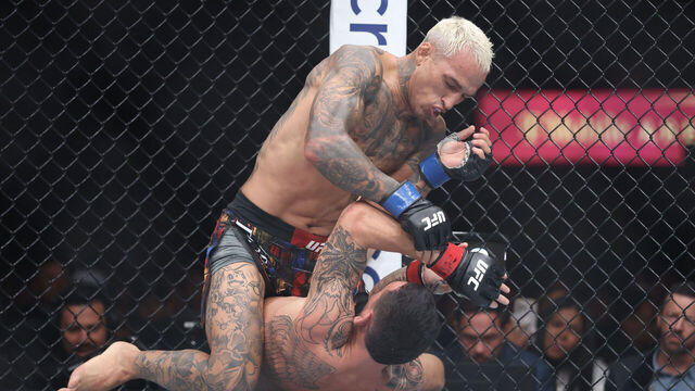 LAS VEGAS, NEVADA - MARCH 07: Charles Oliveira of Brazil strikes Max Holloway of the United States during their BMF title bout at T-Mobile Arena on March 07, 2026 in Las Vegas, Nevada.