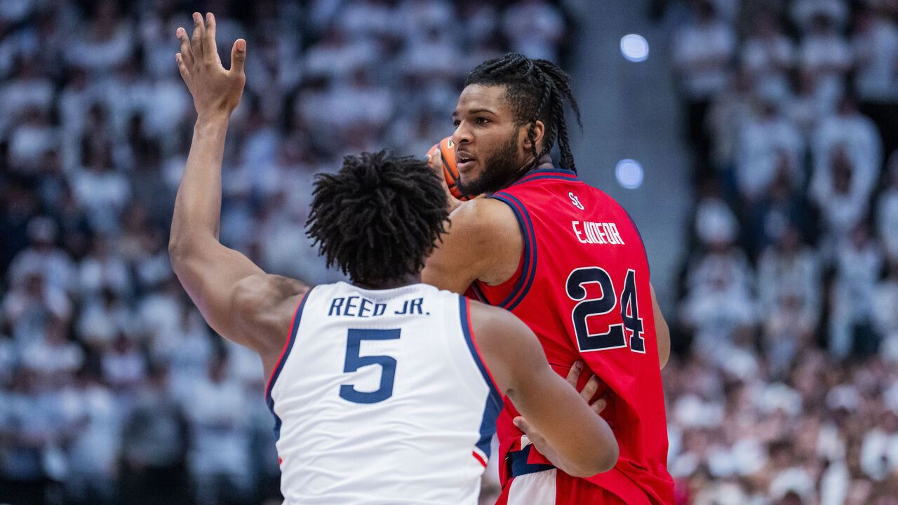 HARTFORD, CONNECTICUT - FEBRUARY 25: Zuby Ejiofor #24 of the St. John's Red Storm is defended by Tarris Reed Jr. #5 of the Connecticut Huskies during the first half of an NCAA men's basketball game at PeoplesBank Arena on February 25, 2026 in Hartford, Connecticut.