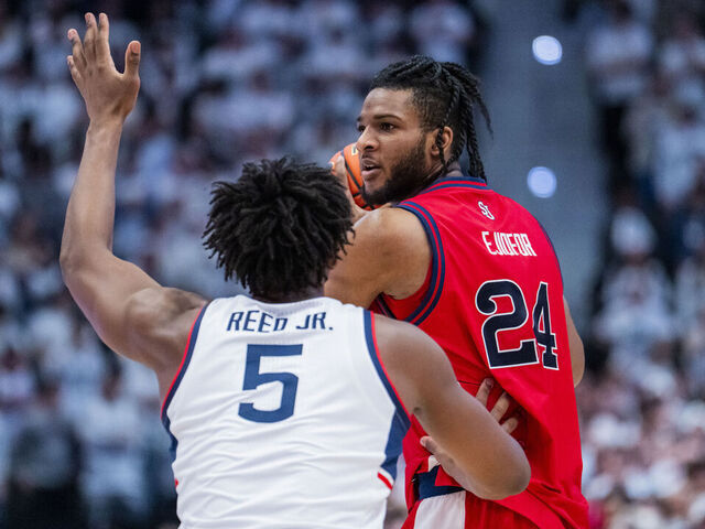 HARTFORD, CONNECTICUT - FEBRUARY 25: Zuby Ejiofor #24 of the St. John's Red Storm is defended by Tarris Reed Jr. #5 of the Connecticut Huskies during the first half of an NCAA men's basketball game at PeoplesBank Arena on February 25, 2026 in Hartford, Connecticut.