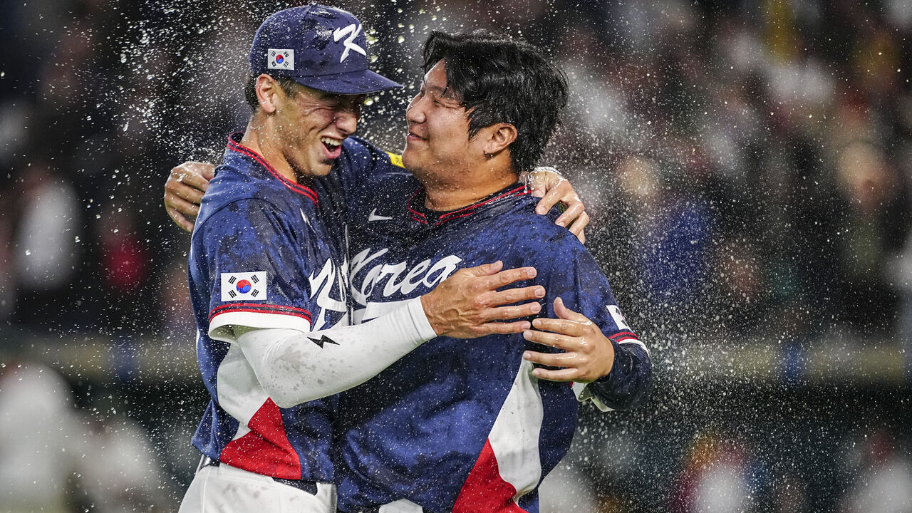 South Korea's Moon Bo-gyeong (R) and Shay Whitcomb celebrate team's victory at the end the World Baseball Classic (WBC) Pool C game between Australia and South Korea at the Tokyo Dome in Tokyo on March 9, 2026.