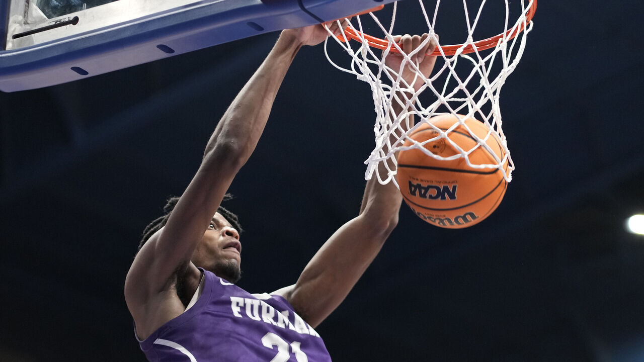 LAWRENCE, KANSAS - NOVEMBER 30: Cooper Bowser #21 of the Furman Paladins dunks against the Kansas Jayhawks in the second half at Allen Fieldhouse on November 30, 2024 in Lawrence, Kansas.