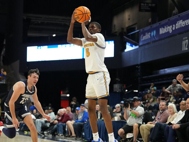 WASHINGTON, DC - MARCH 10: Cruz Davis #5 of the Hofstra Pride takes a jump shot over Jack Collins #13 of the Monmouth Hawks in the first half of the CAA Men's Basketball Championship game at the CareFirst Arena on March 10, 2026 in Washington, DC.