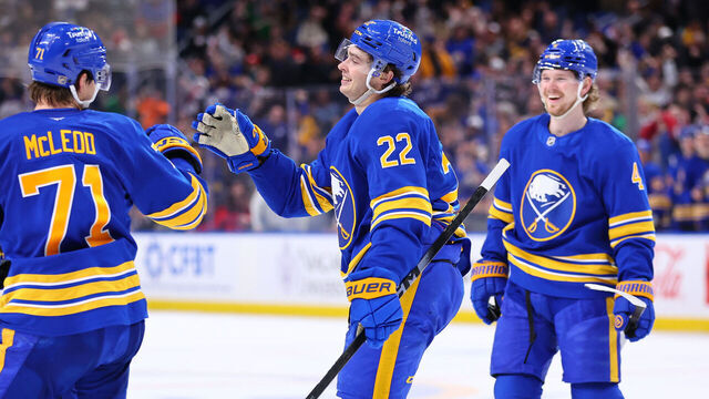BUFFALO, NEW YORK - MARCH 10: Jack Quinn #22 of the Buffalo Sabres celebrates his hat trick goal with Ryan McLeod #71 and Bowen Byram #4 during an NHL game against the San Jose Sharks on March 10, 2026 at KeyBank Center in Buffalo, New York.