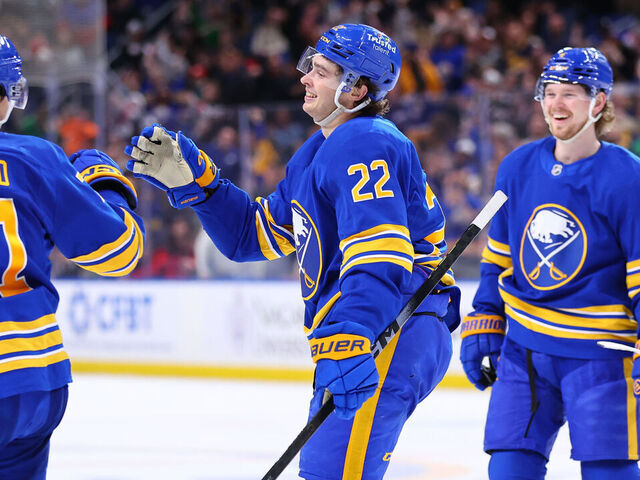 BUFFALO, NEW YORK - MARCH 10: Jack Quinn #22 of the Buffalo Sabres celebrates his hat trick goal with Ryan McLeod #71 and Bowen Byram #4 during an NHL game against the San Jose Sharks on March 10, 2026 at KeyBank Center in Buffalo, New York.