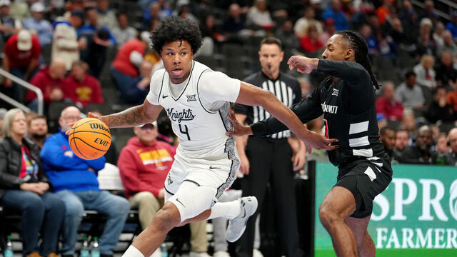 KANSAS CITY, MISSOURI - MARCH 11: Jamichael Stillwell #4 of the UCF Knights drives past Day Day Thomas #1 of the Cincinnati Bearcats in the first half during the second round of the Big 12 Tournament at T-Mobile Center on March 11, 2026 in Kansas City, Missouri.