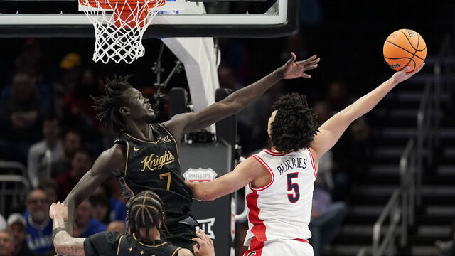 KANSAS CITY, MISSOURI - MARCH 12: Brayden Burries #5 of the Arizona Wildcats lays the ball up against John Bol #7 of the UCF Knights in first half during the quarterfinals of the Big 12 Tournament at T-Mobile Center on March 12, 2026 in Kansas City, Missouri.