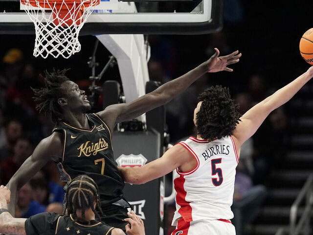 KANSAS CITY, MISSOURI - MARCH 12: Brayden Burries #5 of the Arizona Wildcats lays the ball up against John Bol #7 of the UCF Knights in first half during the quarterfinals of the Big 12 Tournament at T-Mobile Center on March 12, 2026 in Kansas City, Missouri.