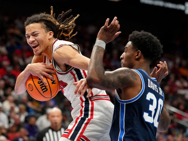 KANSAS CITY, MISSOURI - MARCH 12: Kingston Flemings #4 of the Houston Cougars rebounds against Kennard Davis Jr. #30 of the BYU Cougars in the first half during the quarterfinals of the Big 12 Tournament at T-Mobile Center on March 12, 2026 in Kansas City, Missouri.