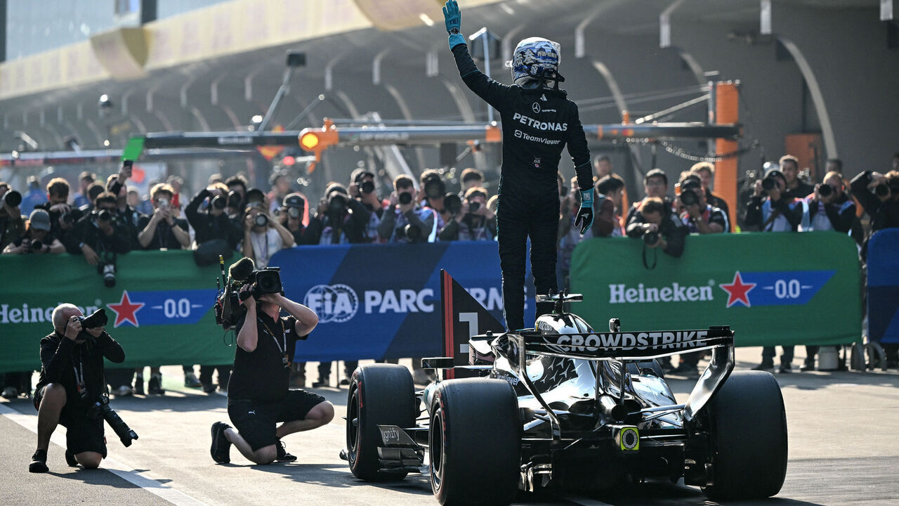 Mercedes' British driver George Russell (C) celebrates getting pole position in the sprint qualifying session ahead of the Formula One Chinese Grand Prix at the Shanghai International Circuit in Shanghai on March 13, 2026.