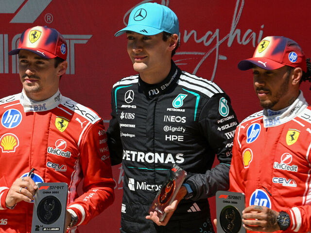 Mercedes' British driver George Russell (C) celebrates winning next to second-placed Ferrari's Monegasque driver Charles Leclerc (L) and third-placed Ferrari's British driver Lewis Hamilton (R) after the sprint race ahead of the Formula One Chinese Grand Prix at the Shanghai International Circuit in Shanghai on March 14, 2026.