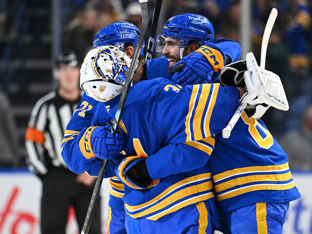 BUFFALO, NEW YORK - MARCH 14: Alex Tuch #89 and Ryan McLeod #71 celebrate with teammate Alex Lyon #34 of the Buffalo Sabres after winning an NHL game against the Toronto Maple Leafs at KeyBank Center on March 14, 2026 in Buffalo, New York. Buffalo won 3-2 in a shootout.