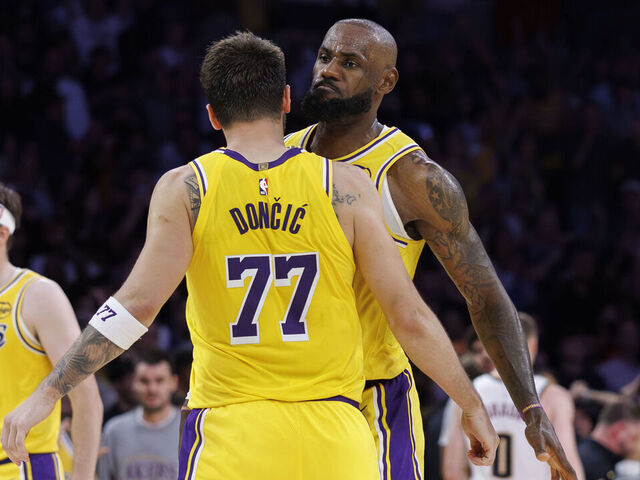 LOS ANGELES, CA - MARCH 14, 2026: Los Angeles Lakers forward LeBron James (23) and Los Angeles Lakers guard Austin Reaves (15) react with Los Angeles Lakers guard Luka Doncic (77) after Doncic scored the game winning basket in overtime against the Denver Nuggets at Crypto.com Arena on March 14, 2026 in Los Angeles, California.(Gina Ferazzi / Los Angeles Times via Getty Images)
