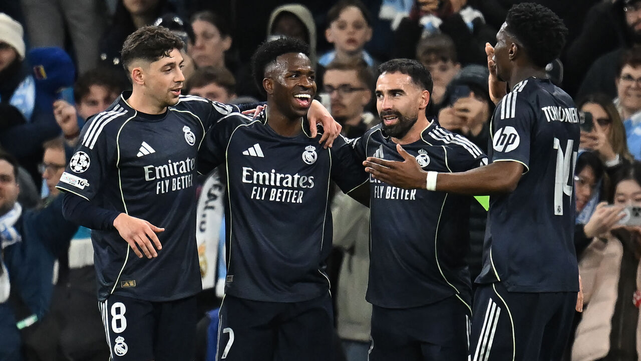 Real Madrid's Brazilian forward #07 Vinicius Junior (2L) celebrates after scoring their late second goal during the UEFA Champions League, round of 16 second leg football match between Manchester City and Real Madrid at the Etihad Stadium in Manchester, north west England, on March 17, 2026.