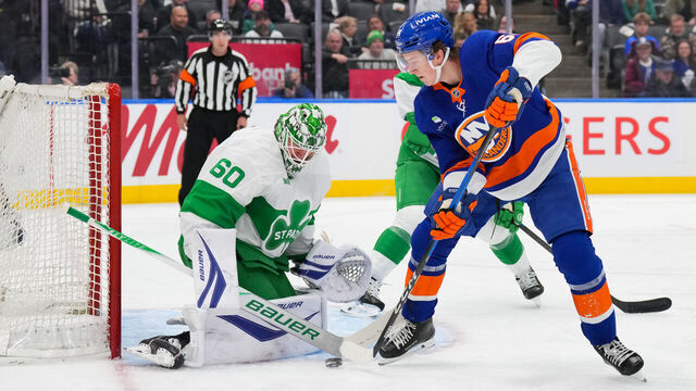 TORONTO, CANADA - MARCH 17: Calum Ritchie #64 of the New York Islanders passes the puck past Joseph Woll #60 of the Toronto Maple Leafs in the first period at Scotiabank Arena on March 17, 2026 in Toronto, Ontario, Canada.