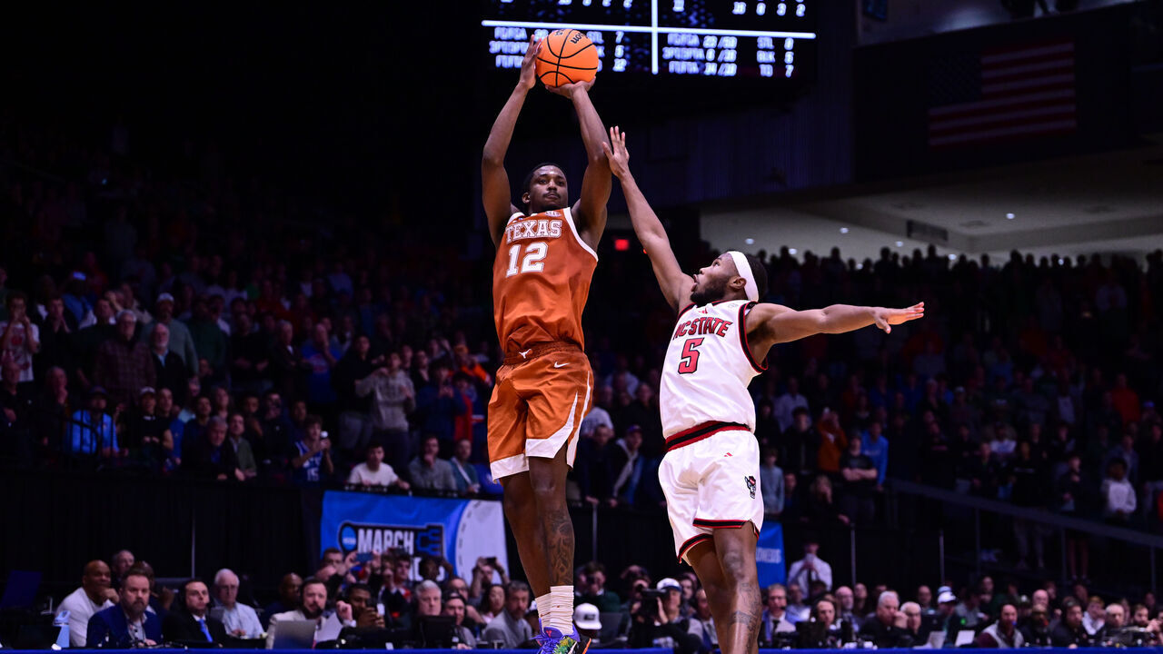 DAYTON, OHIO - MARCH 17: Tramon Mark #12 of the Texas Longhorns makes the game-winning basket as Tre Holloman #5 of the North Carolina State Wolfpack defends during the First Four round of the 2026 NCAA Men's Basketball tournament held at UD Arena on March 17, 2026 in Dayton, Ohio.