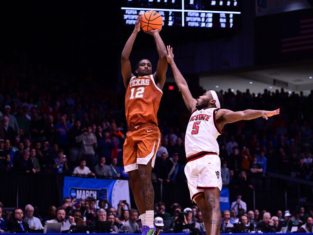 DAYTON, OHIO - MARCH 17: Tramon Mark #12 of the Texas Longhorns makes the game-winning basket as Tre Holloman #5 of the North Carolina State Wolfpack defends during the First Four round of the 2026 NCAA Men's Basketball tournament held at UD Arena on March 17, 2026 in Dayton, Ohio.