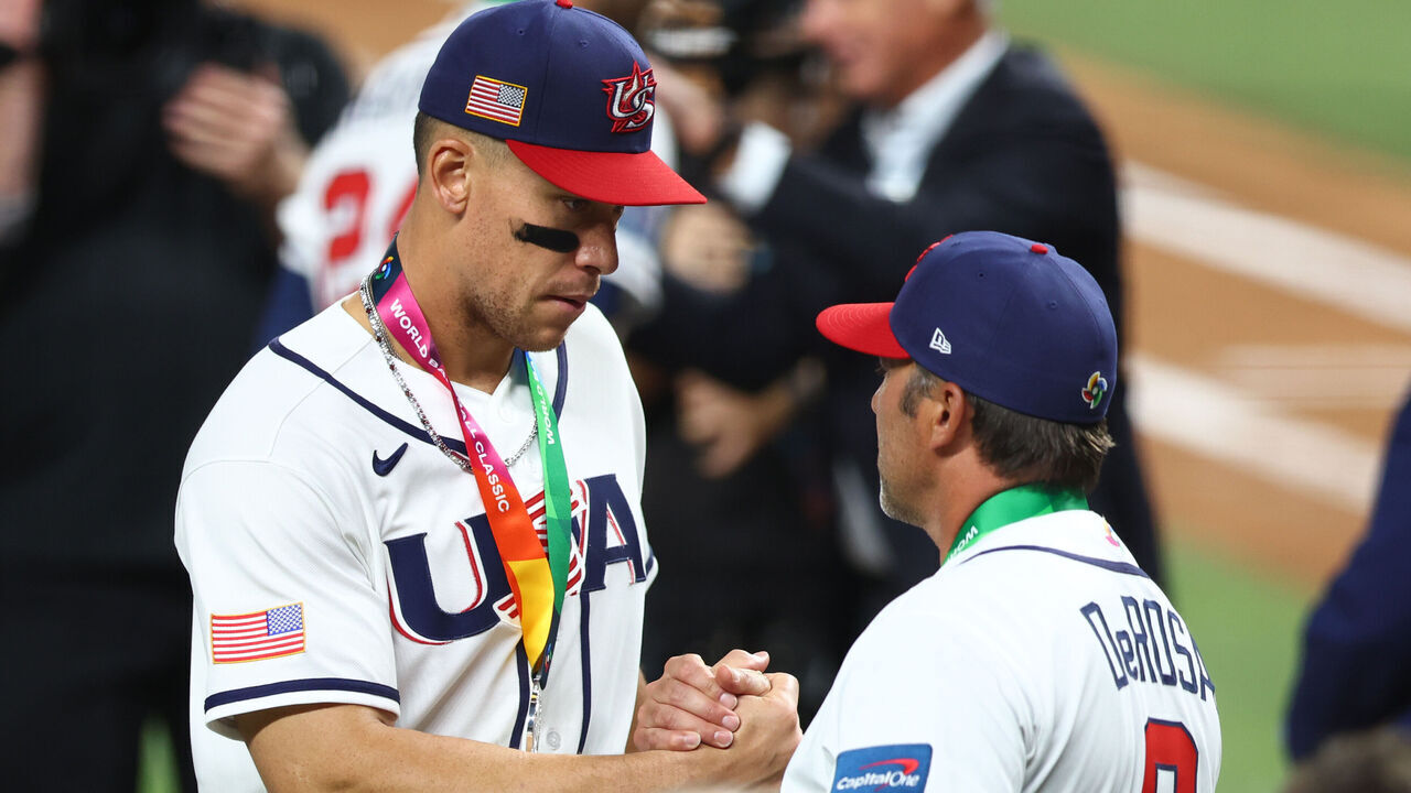 MIAMI, FLORIDA - MARCH 17: Aaron Judge #99 and manager Mark DeRosa #9 of Team United States shake hands after receiving their silver medals following the 3-2 defeat against Team Venezuela at loanDepot park on March 17, 2026 in Miami, Florida.