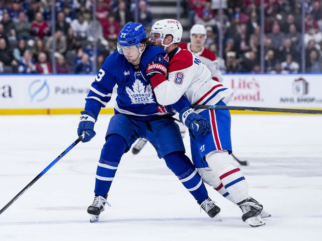 TORONTO, CANADA - DECEMBER 6: Matthew Knies #23 of the Toronto Maple Leafs and Mike Matheson #8 of the Montreal Canadiens battle during the first period at the Scotiabank Arena on December 6, 2025 in Toronto, Ontario, Canada.