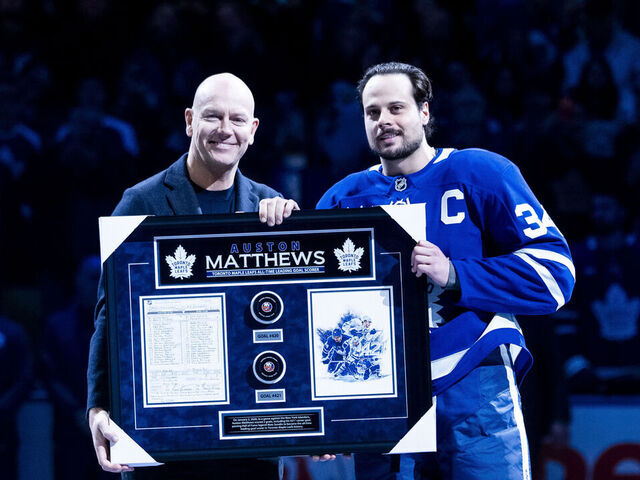 TORONTO, CANADA - JANUARY 6: Toronto Maple Leafs Alumni Matts Sundin presents Auston Matthews #34 of the Toronto Maple Leafs with an award for surpassing his all-time goal scoring record with 421 goals before a game against the Florida Panthers at the Scotiabank Arena on January 6, 2026 in Toronto, Ontario, Canada.