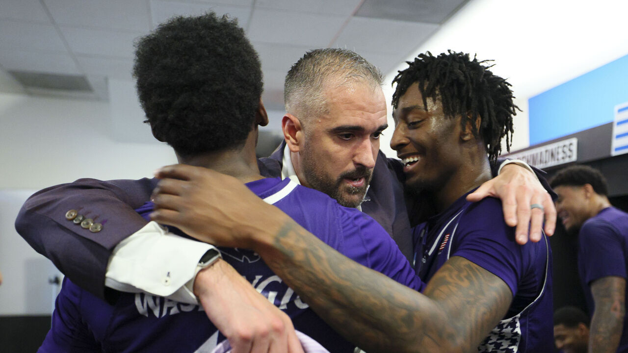 PORTLAND, OREGON - MARCH 19: head coach Flynn Clayman of the High Point Panthers is embraced by guard Scotty Washington #12 and forward Terry Anderson #5 after upsetting the Wisconsin Badgers in the first round of the 2026 NCAA Men's Basketball Tournament held at Moda Center on March 19, 2026 in Portland, Oregon.