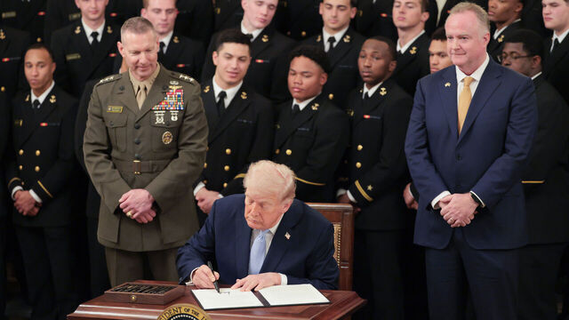 WASHINGTON, DC - MARCH 20: U.S. President Donald Trump displays an executive order he signed titled "Preserving America's Game" to preserve the broadcast time slot for the Army v Navy football game during a ceremony awarding the Commander-in-Chief Trophy to the Navy Midshipmen football team in the East Room of the White House March 20, 2026 in Washington, DC. The Commander-in-Chief Trophy is awarded each year to the winner of the Army-Navy football game.