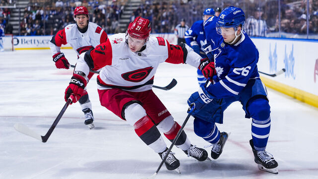 TORONTO, CANADA - MARCH 20: Jacob Quillan #26 of the Toronto Maple Leafs and Alexander Nikishin #21 of the Carolina Hurricanes battle for the puck during the third period at the Scotiabank Arena on March 20, 2026 in Toronto, Ontario, Canada.