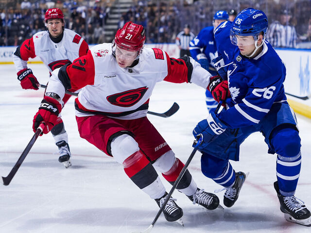 TORONTO, CANADA - MARCH 20: Jacob Quillan #26 of the Toronto Maple Leafs and Alexander Nikishin #21 of the Carolina Hurricanes battle for the puck during the third period at the Scotiabank Arena on March 20, 2026 in Toronto, Ontario, Canada.