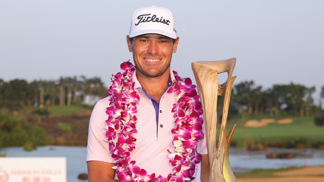 Jordan Gumberg of the US poses with the trophy after winning the DP World Tour Hainan Classic golf tournament at the Mission Hills golf course in Haikou, in China's southern Hainan province on March 22, 2026. / China OUT