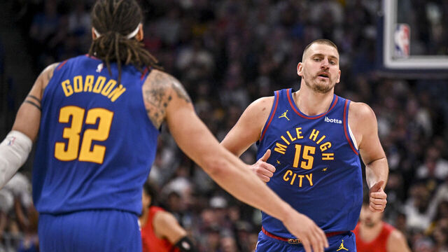 DENVER , CO - MARCH 22: Nikola Jokic (15) of the Denver Nuggets jogs towards the outstretched hand of Aaron Gordon (32) after scoring against the Portland Trail Blazers during the third quarter at Ball Arena in Denver, Colorado on Sunday, March 22, 2026.