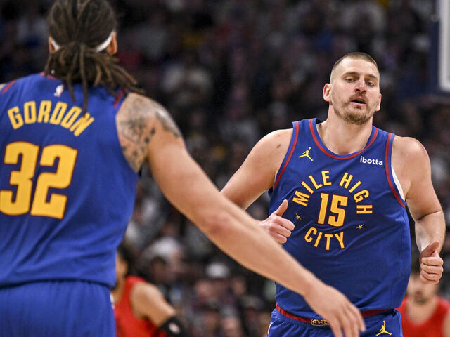 DENVER , CO - MARCH 22: Nikola Jokic (15) of the Denver Nuggets jogs towards the outstretched hand of Aaron Gordon (32) after scoring against the Portland Trail Blazers during the third quarter at Ball Arena in Denver, Colorado on Sunday, March 22, 2026.