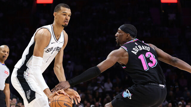MIAMI, FLORIDA - MARCH 23: Victor Wembanyama #1 of the San Antonio Spurs drives against Bam Adebayo #13 of the Miami Heat during the first quarter of the game at Kaseya Center on March 23, 2026 in Miami, Florida.