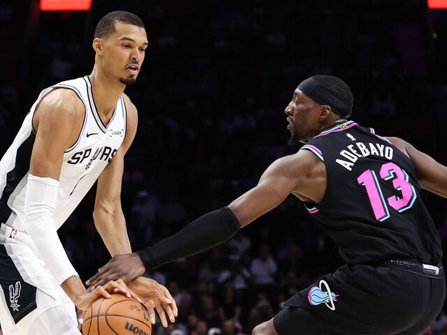 MIAMI, FLORIDA - MARCH 23: Victor Wembanyama #1 of the San Antonio Spurs drives against Bam Adebayo #13 of the Miami Heat during the first quarter of the game at Kaseya Center on March 23, 2026 in Miami, Florida.