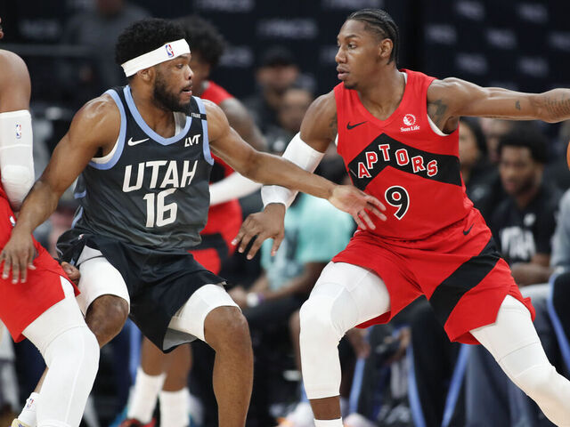 SALT LAKE CITY, UT - MARCH 23: Elijah Harkless #16 of the Utah Jazz tries to get to RJ Barrett #9 of the Toronto Raptors as Collin Murray-Bowles #12 sets a pick during the first half of their game at the Delta Center on March 23, 2026 in Salt Lake City, Utah.