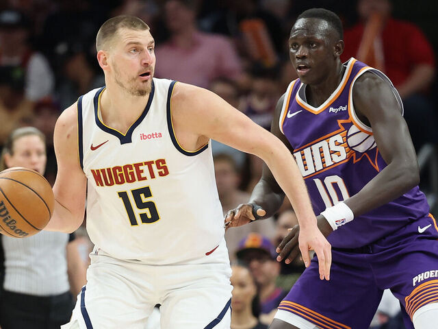 PHOENIX, ARIZONA - MARCH 24: Nikola Jokic #15 of the Denver Nuggets handles the ball against Khaman Maluach #10 of the Phoenix Suns during the first half of the NBA game at Mortgage Matchup Center on March 24, 2026 in Phoenix, Arizona.