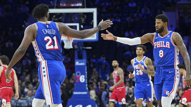 PHILADELPHIA, PENNSYLVANIA - MARCH 25: Joel Embiid #21 of the Philadelphia 76ers celebrates with Paul George #8 against the Chicago Bulls in the first quarter at Xfinity Mobile Arena on March 25, 2026 in Philadelphia, Pennsylvania.