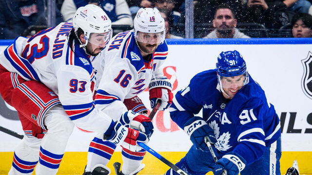TORONTO, ON - MARCH 25: Toronto Maple Leafs Center John Tavares (91) reaches for the puck against New York Rangers Center Mika Zibanejad (93) during the third period of the NHL regular season game between the New York Rangers and the Toronto Maple Leafs on March 25, 2026, at Scotiabank Arena in Toronto, ON, Canada.