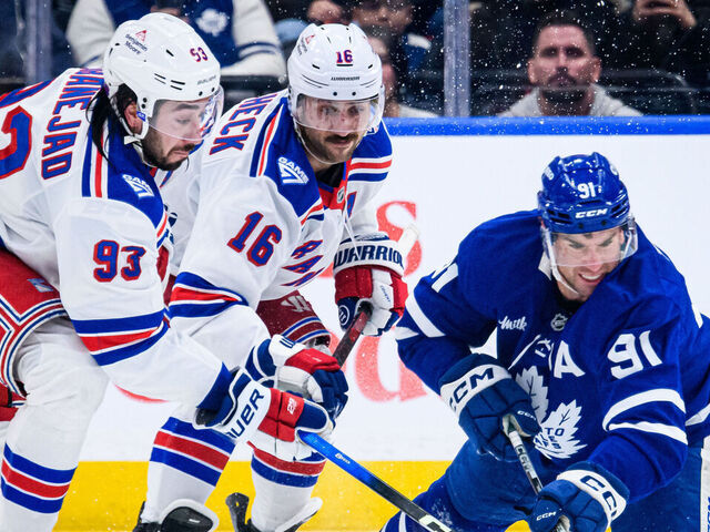 TORONTO, ON - MARCH 25: Toronto Maple Leafs Center John Tavares (91) reaches for the puck against New York Rangers Center Mika Zibanejad (93) during the third period of the NHL regular season game between the New York Rangers and the Toronto Maple Leafs on March 25, 2026, at Scotiabank Arena in Toronto, ON, Canada.