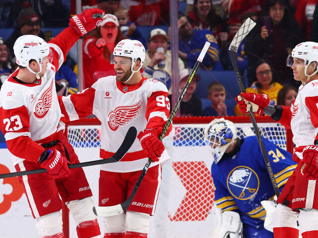 BUFFALO, NEW YORK - MARCH 27: Alex DeBrincat #93 of the Detroit Red Wings celebrates his first period goal against Alex Lyon #34 of the Buffalo Sabres with Lucas Raymond #23 and Patrick Kane #88 during an NHL game on March 27, 2026 at KeyBank Center in Buffalo, New York.