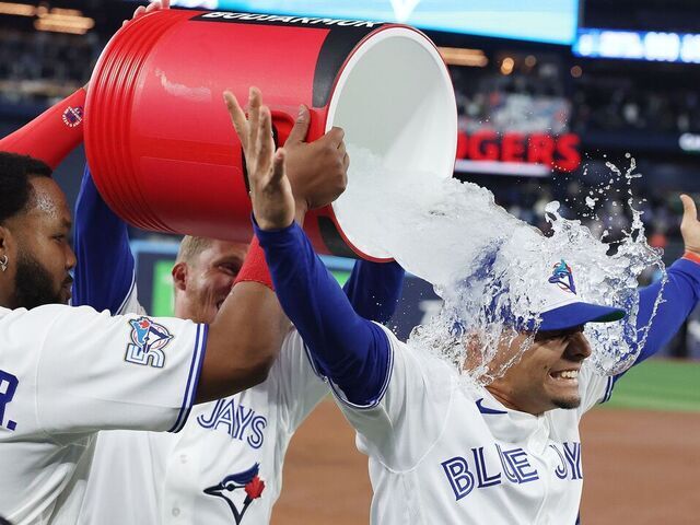 TORONTO, ON- MARCH 27 - First baseman Vladimir Guerrero Jr. #27 of the Toronto Blue Jays and Myles Straw #3 of the Toronto Blue Jays douse second baseman Andrés Giménez #0 of the Toronto Blue Jays in ice water after he had all three Toronto Blue Jays RBI's as the Toronto Blue Jays beat the Athletics in the season opener 3-2 at Rogers Centre in Toronto. March 27, 2026. Steve Russell/Toronto Star (Steve Russell/Toronto Star via Getty Images)