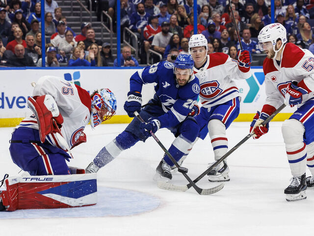 TAMPA, FL - MARCH 31: Zemgus Girgensons #28 of the Tampa Bay Lightning battles for the puck against goalie Jakub Dobes #75, Cole Caufield #13, and Noah Dobson #53 of the Montreal Canadiens at Benchmark International Arena on March 31, 2026 in Tampa, Florida.